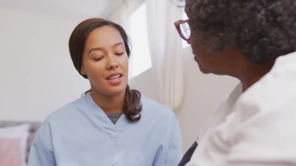 Mixed race woman being visited at home by a nurse. Social distancing and self isolation in quarantin