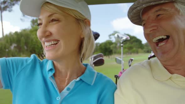 Two golfers driving in their golf buggy