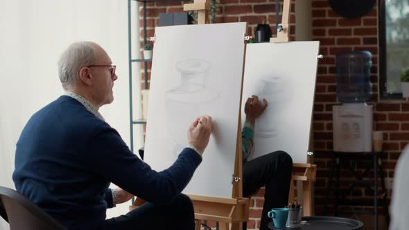 Old Student Using Pencil to Sketch Vase Model in Creative Workshop