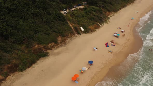 Aerial Drone Top View Over Ocean Sea White Sand Beach Rocky Mountains Cliffs and Dense Forest Bright