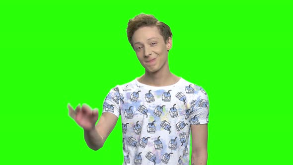 Teenage Boy Showing OK Sign Isolated on Green