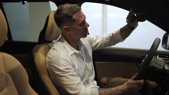 Client in White Shirt Sit in Car Salon Touch Mirror Want Buy New Automobile in Showroom