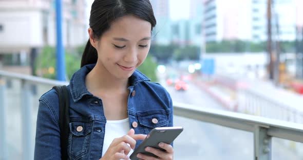 Woman use of mobile phone in city 