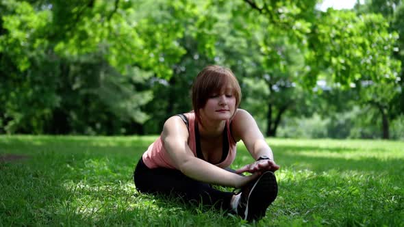 Girl Doing Stretching on the Grass in the Park