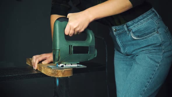 Woman Processing the Piece of Wood using Jigsaw 