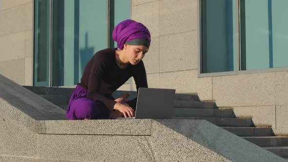 Islamic Muslim Business Woman Student User Sits Outdoors Background of City Building Working