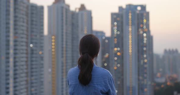 Woman look at the building and think in city of Hong Kong