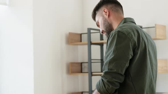 Man with Adhesive Tape Gun Packing Box at Home