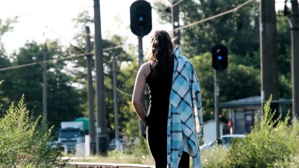 Young Beautiful Woman Walks Alone on the Railway Track