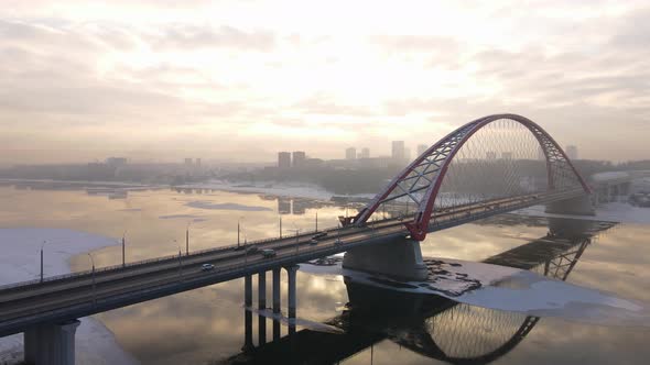 Large Bridge on the Background of Sunset Is Reflected in the River