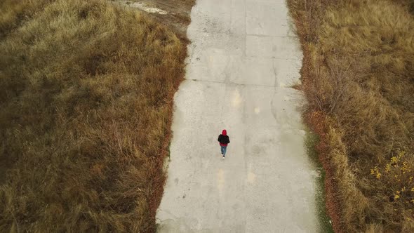 Aerial View of Woman Going on Destroyed Road Alone in Countryside