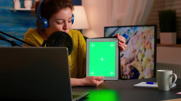 Influencer Holding Tablet with Green Screen Speaking During Podcast