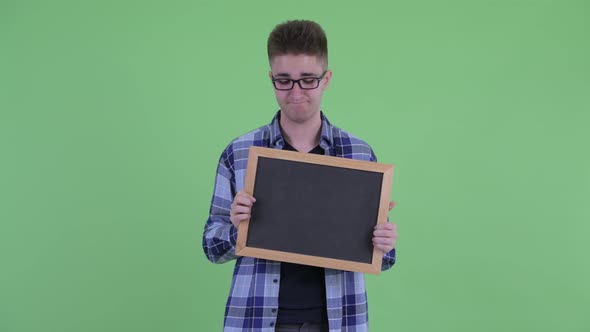 Stressed Young Hipster Man Holding Blackboard