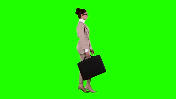 Girl with Cases in Her Hands Goes To Work. Green Screen. Side View. Slow Motion