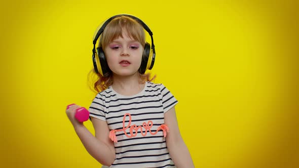 Child Girl Listening Music Via Headphones Working Out Pumping Up Arm Muscles Lifting Pink Dumbbells
