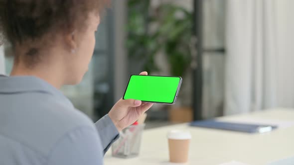 Rear View of African Woman Looking at Smartphone with Green Chroma Key Screen