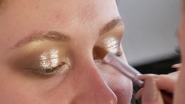 Beautiful Shiny Shadows are Applied with a Special Brush on the Eyelid of the Model