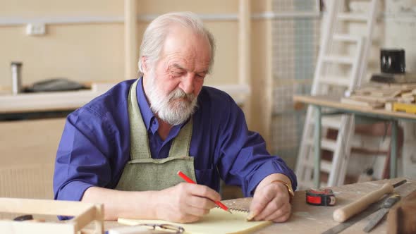 Old Artisan in Working Outfit Writing Designing Ideas.