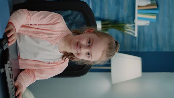 Vertical Video Portrait of Child Sitting at Desk with Computer for Online Lessons