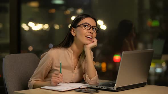 Inspired Woman Writing Startup Ideas Into Notebook, Dreaming of Own Business