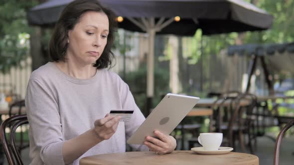 Online Shopping Failure on Tablet for Old Woman Sitting Outdoor