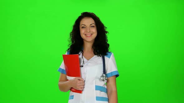 Smiling Nurse with Stethoscope and Medical Journal in Hand Smiling