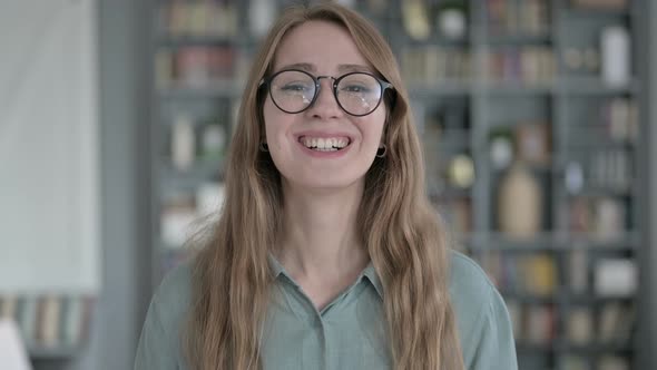 Portrait of Young Woman Waving and Talking in Office