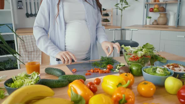 Pregnant Woman Preparing Organic Healthy Food Slicing Vegetables for Salad