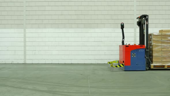 Forked Automatic Guided Vehicles (AGV) pallet truck goes into an elevator