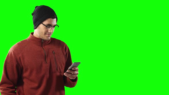 Caucasian man using a smartphone on green background