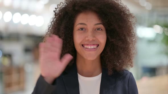 Cheerful Young African Businesswoman Waving at the Camera