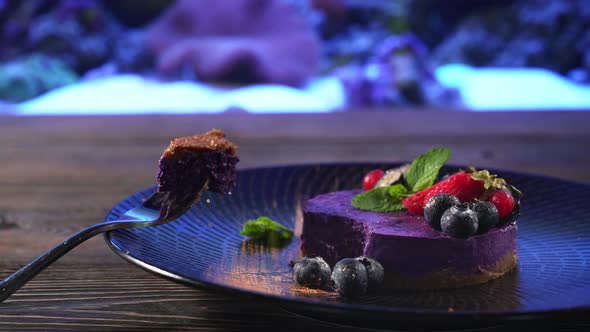 Piece of Purple Cheesecake on Fork Near Aquarium.