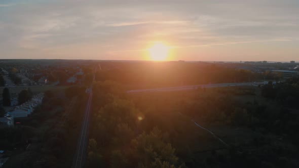 Slow scenic aerial flight over train tracks outside nepean city, ontario at sunrise with the sun shi