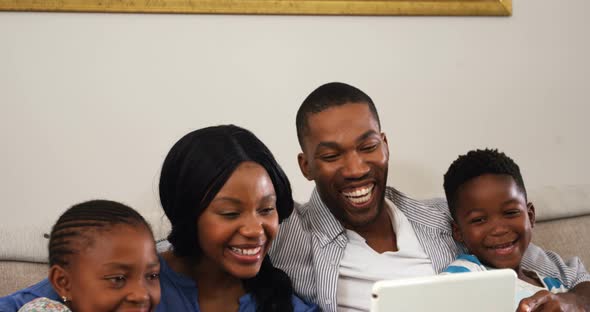 Family using digital tablet in living room 4k