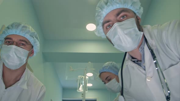 Group of Surgeons Looking Down at Patient on the Way To Operation Room