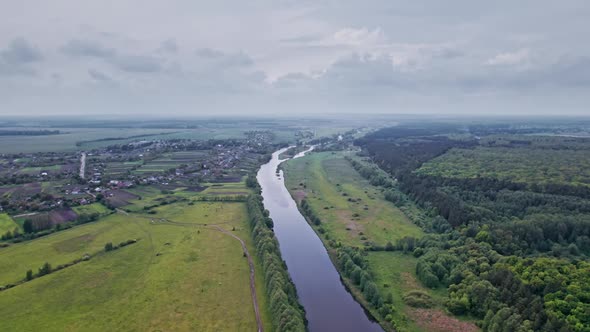 Top View of the River Surrounded By Trees and Meadows