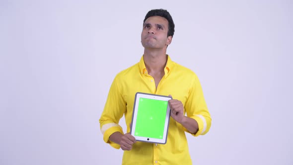 Happy Young Indian Businessman Thinking While Showing Digital Tablet