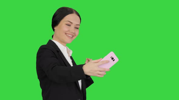 Smiling Businesswoman Taking Selfie on Her Phone on a Green Screen Chroma Key