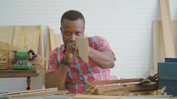 Male carpenter blogger filming video showing wooden planks items through tablet while video online 