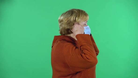 Senior Woman Is Puts a Medical Mask on Her Face To Protecting Yourself From Coronavirus Pandemic