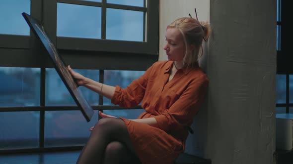 Gifted Female Artist Admiring Her Artwork in Studio