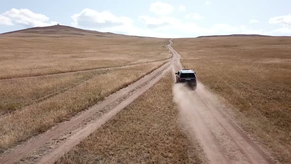 Aerial Footage Filmed with Drone of Pickup Car Riding on the Siberian Steppe