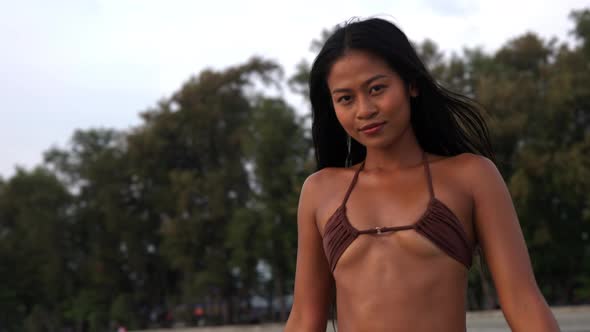 Beautiful Young Woman In Bikini Walking Along Beach
