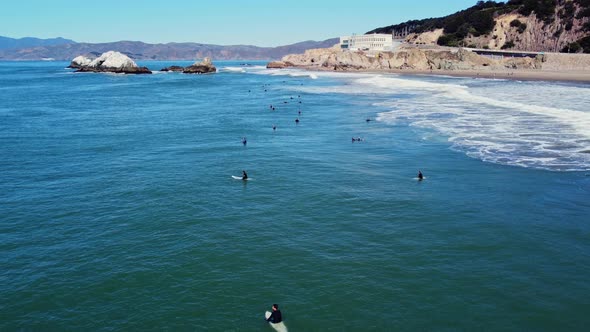 Surfers Sitting On Surfboard Waiting For Perfect Wave To Surf In San Francisco Ocean Beach, Californ