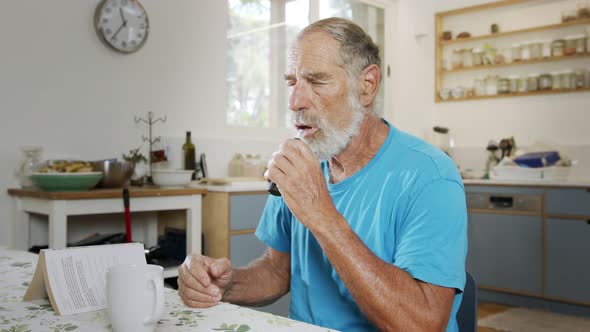 Man with Parkinson's disease using medical Cannabis in vaporizer to stop shaking