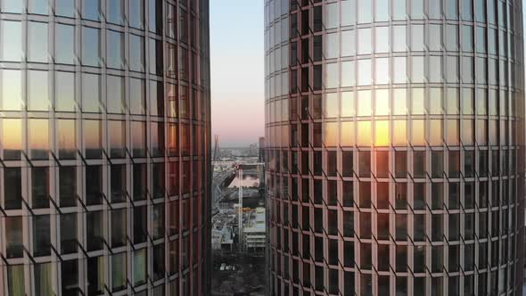 Close up aerial reveal of Zunda glass towers on a sunset with city of Riga in between with clear pin