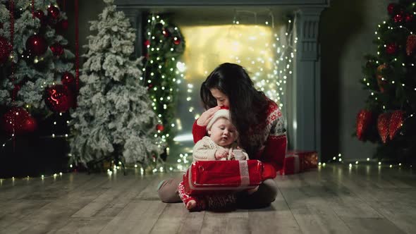 Baby with Mother Opens Gift