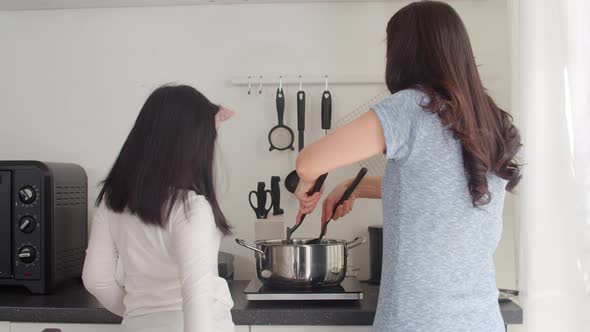Lifestyle women happy making pasta and spaghetti together for breakfast meal in the kitchen