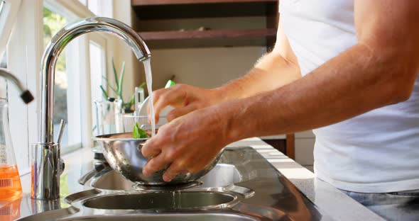 Senior man cleaning vegetable in kitchen at home 4k