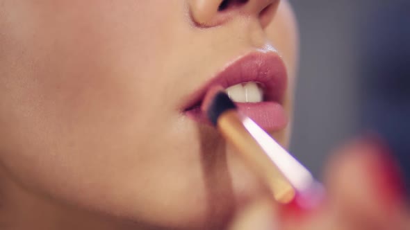 Closeup View of a Professional Makeup Artist Applying Lipstick on Model's Lips Working in Beauty